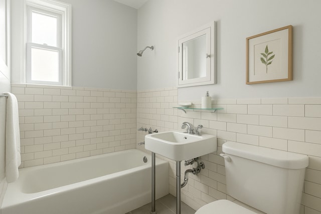 full bathroom with tile walls, toilet, a bathtub, a wainscoted wall, and a sink