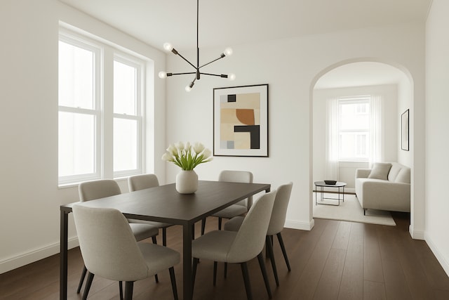 dining area with baseboards, arched walkways, a chandelier, and dark wood-style flooring