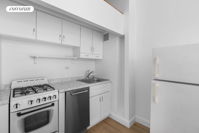 kitchen with white appliances, open shelves, a sink, light countertops, and light wood-style flooring