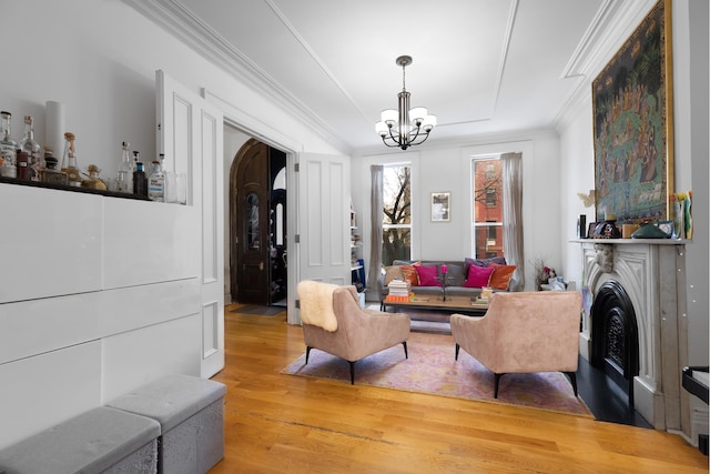 6 3rd St, New York City, NY 11231 - living room featuring an inviting chandelier, ornamental molding, a fireplace, light wood-type flooring, and a raised ceiling
