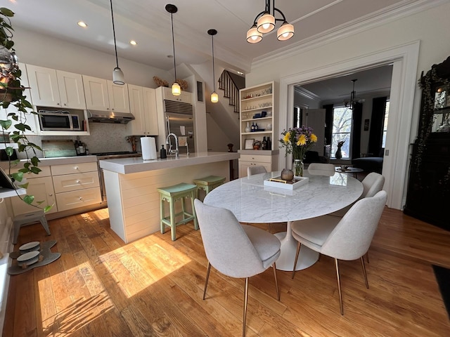 6 3rd St, New York City, NY 11231 - dining area with crown molding, an inviting chandelier, stairs, recessed lighting, and light wood finished floors