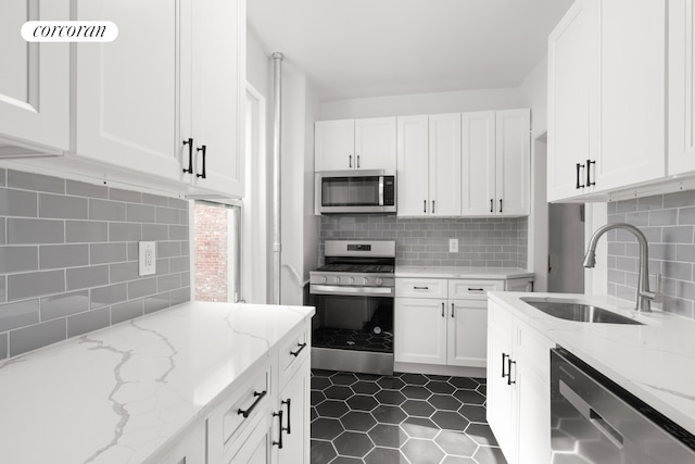 720 W 173rd St Unit 32, New York City, NY 10032 - kitchen with appliances with stainless steel finishes, a sink, decorative backsplash, and white cabinets