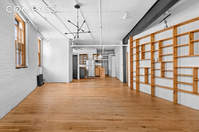 210 Spring St Unit 5, New York City, NY 10012 - interior space with freestanding refrigerator, brick wall, and hardwood / wood-style floors