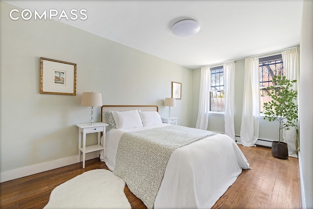 118 Union St Unit 9A, New York City, NY 11231 - bedroom with baseboards, wood finished floors, and a baseboard radiator