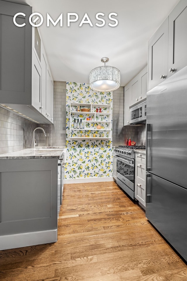 118 Union St Unit 9A, New York City, NY 11231 - kitchen featuring appliances with stainless steel finishes, tasteful backsplash, light wood-style flooring, and a sink