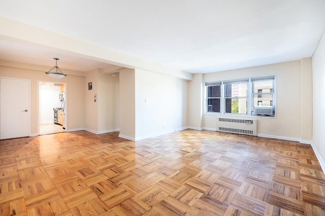 spare room featuring radiator and baseboards