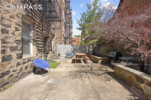 view of patio / terrace with a grill and fence