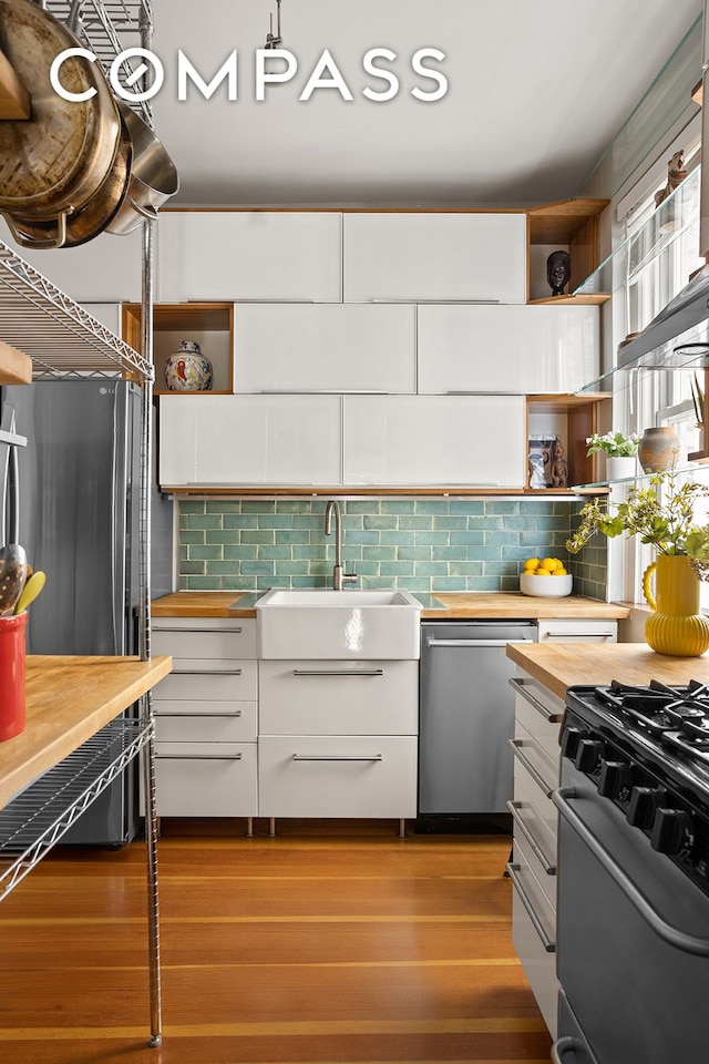 kitchen with dark wood-style floors, open shelves, white cabinetry, wooden counters, and appliances with stainless steel finishes