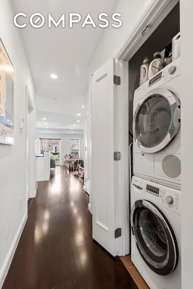 clothes washing area featuring stacked washer / dryer, dark wood-style flooring, and recessed lighting