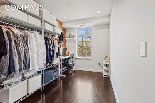 walk in closet with wood finished floors