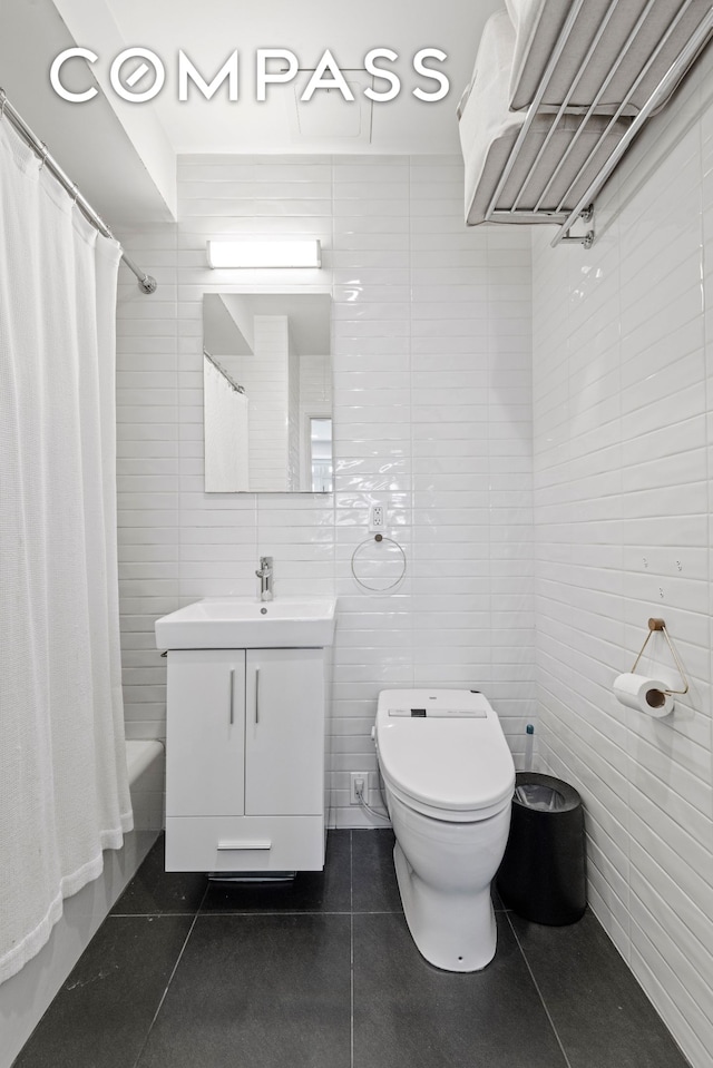 bathroom with tile walls, tile patterned flooring, toilet, vanity, and shower / bath combo with shower curtain