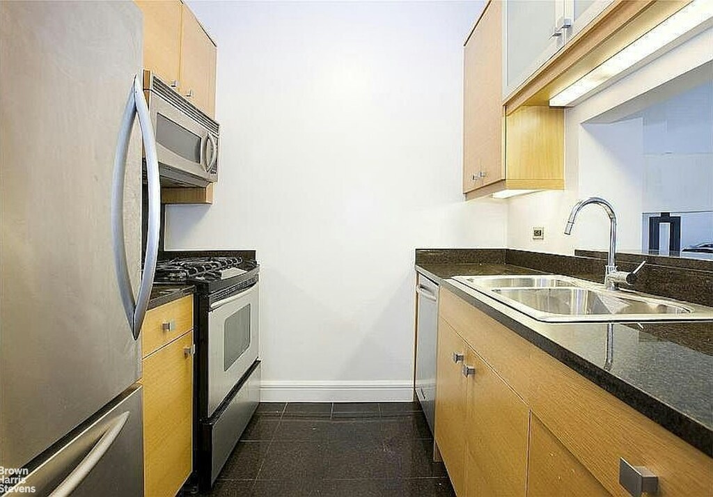 120 Riverside Blvd Unit 7H, New York City, NY 10069 - kitchen featuring stainless steel appliances, a sink, dark countertops, and baseboards