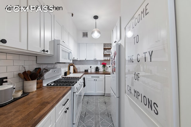 126 W 78th St, New York City, NY 10024 - kitchen with wooden counters, white appliances, a sink, decorative backsplash, and white cabinets