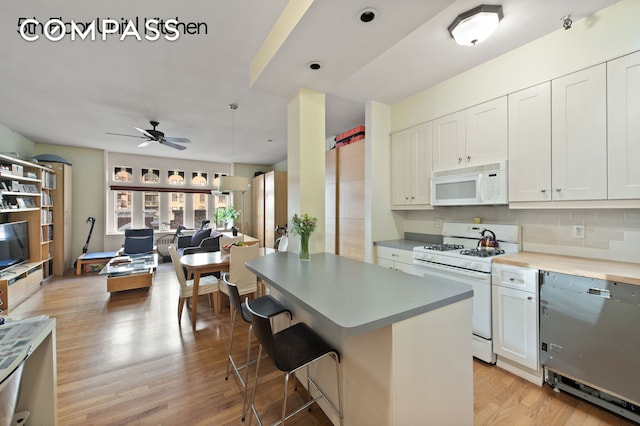 126 W 78th St, New York City, NY 10024 - kitchen with white appliances, open floor plan, light wood-style flooring, decorative backsplash, and a ceiling fan