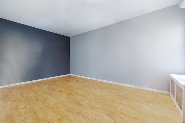 spare room featuring light wood-style flooring and baseboards