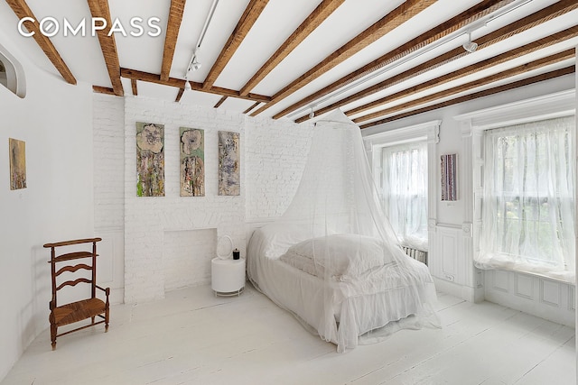 bedroom with radiator heating unit and beamed ceiling