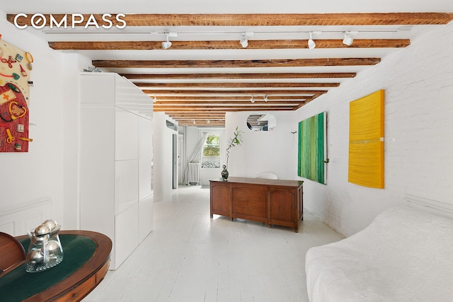 interior space featuring light wood-style floors, radiator, and beamed ceiling