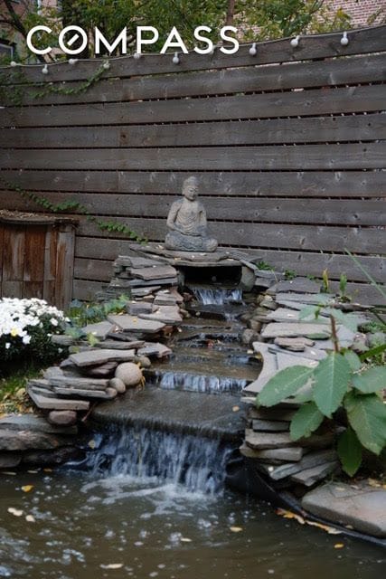 details featuring fence and a small pond