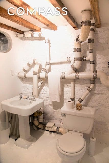half bath with toilet and beam ceiling