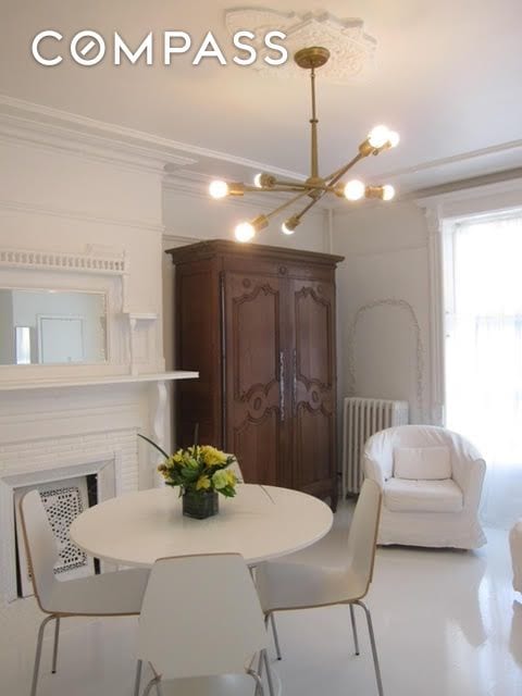 dining space featuring crown molding, a notable chandelier, and radiator heating unit