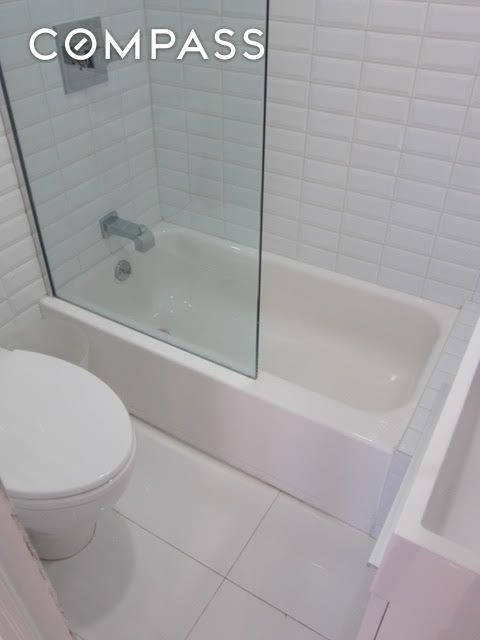 bathroom with toilet, tile patterned floors, and shower / bathing tub combination
