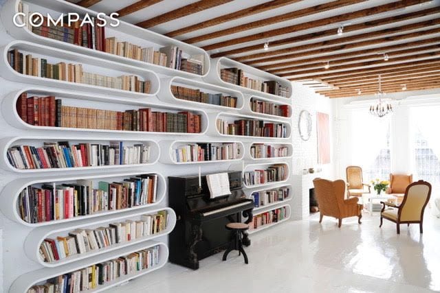 sitting room with a notable chandelier and bookshelves