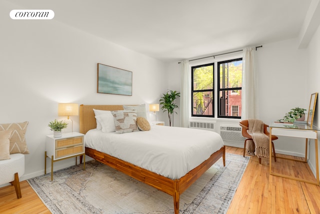 bedroom with wood finished floors and baseboards