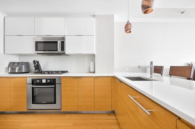 303 E 33rd St Unit 7C, New York City, NY 10016 - kitchen with appliances with stainless steel finishes, a sink, light countertops, and modern cabinets