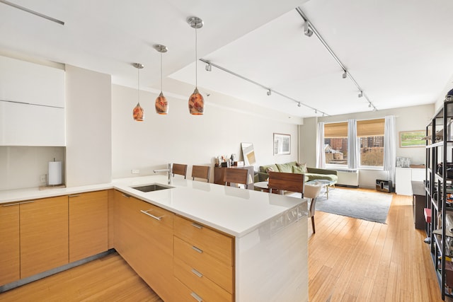 303 E 33rd St Unit 7C, New York City, NY 10016 - kitchen with a sink, light wood-style flooring, a peninsula, track lighting, and open floor plan