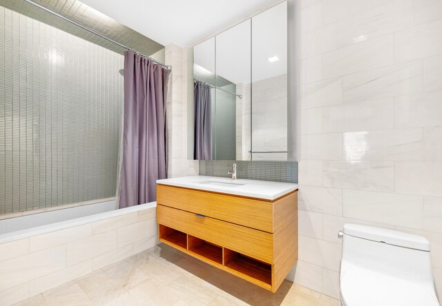 303 E 33rd St Unit 7C, New York City, NY 10016 - bathroom with vanity, tile walls, a tile shower, toilet, and tile patterned floors