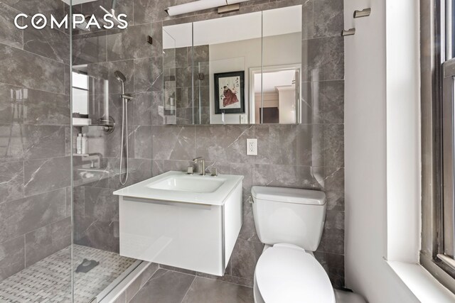 full bathroom featuring a tile shower and tile walls