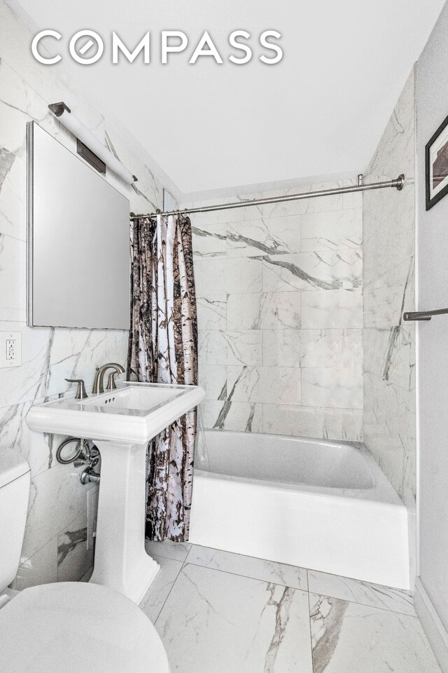 bathroom with shower / tub combo, toilet, and marble finish floor