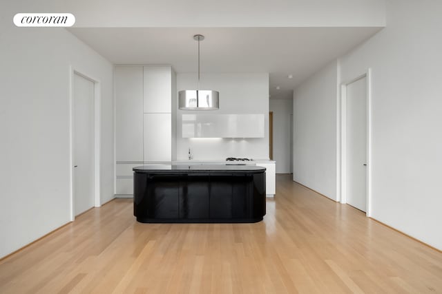 56 Leonard St Unit 44Be, New York City, NY 10013 - kitchen featuring white cabinets, light wood-style flooring, a kitchen island, and modern cabinets