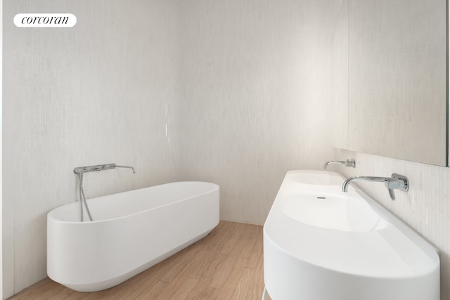 56 Leonard St Unit 44Be, New York City, NY 10013 - full bathroom featuring a freestanding tub and wood finished floors