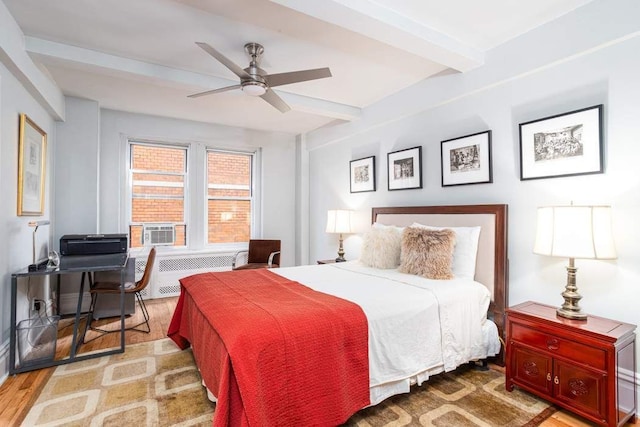 433 W 34th St Unit 5L, New York City, NY 10001 - bedroom with radiator, beam ceiling, a desk, wood finished floors, and cooling unit