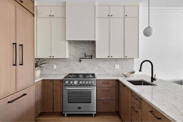 80 Cornelia St Unit 2, New York City, NY 11221 - kitchen featuring high end stainless steel range oven, a sink, light stone counters, decorative backsplash, and white cabinetry