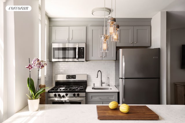 67-30 Clyde St Unit 5P, New York City, NY 11375 - kitchen featuring appliances with stainless steel finishes, a sink, gray cabinetry, backsplash, and hanging light fixtures