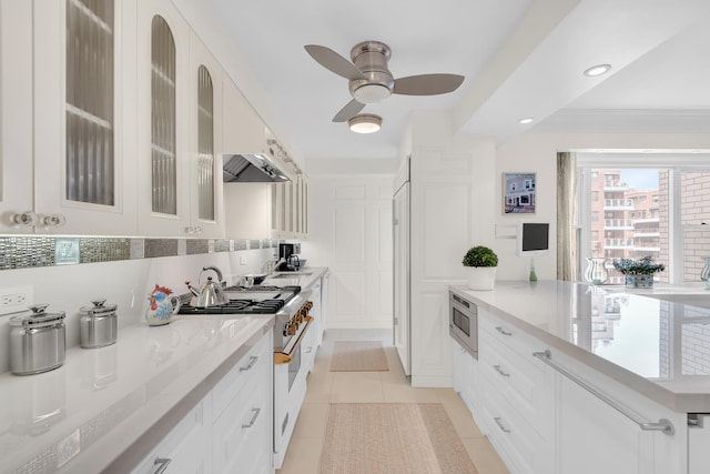 kitchen featuring a ceiling fan, light tile patterned floors, glass insert cabinets, stainless steel appliances, and white cabinetry