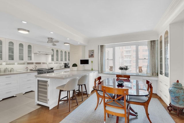 dining space featuring crown molding, ceiling fan, recessed lighting, and beverage cooler