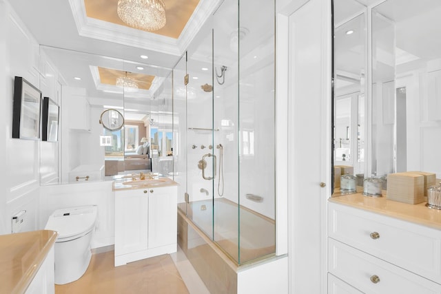 bathroom with vanity, ornamental molding, toilet, a raised ceiling, and enclosed tub / shower combo