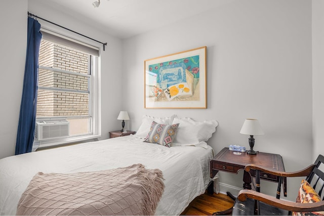 bedroom featuring wood finished floors and cooling unit