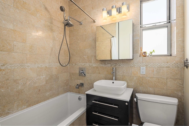 bathroom with shower / bath combo with shower curtain, toilet, vanity, and tile walls