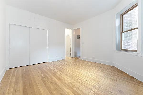 unfurnished bedroom featuring light wood-style floors, baseboards, and a closet