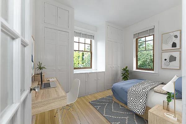 bedroom with two closets and light wood finished floors