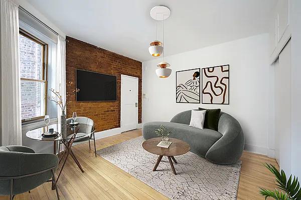 living area featuring baseboards, brick wall, and light wood-type flooring
