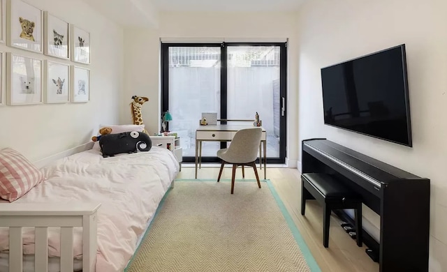 bedroom featuring light wood-style floors and baseboards