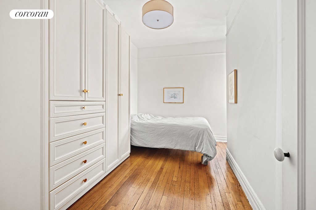 bedroom with light wood-type flooring and baseboards