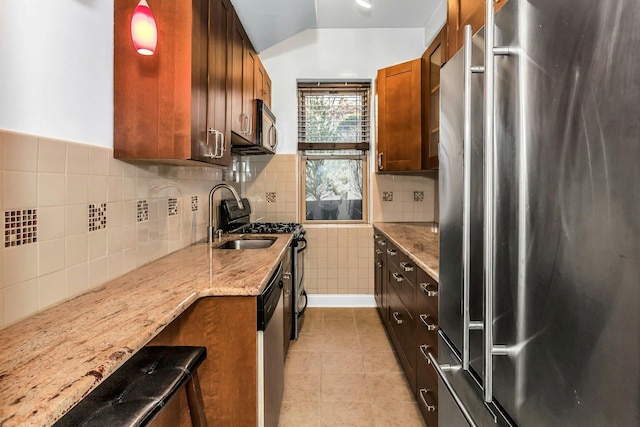 67-25 Clyde St Unit 1G, New York City, NY 11375 - kitchen featuring decorative backsplash, light stone counters, a sink, light tile patterned floors, and stainless steel appliances