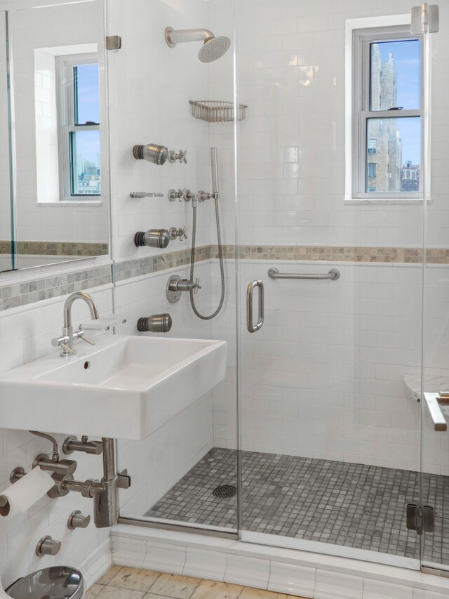 full bathroom with a shower stall, healthy amount of natural light, and tile walls