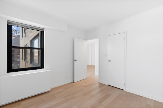 unfurnished bedroom featuring light wood-style floors and baseboards